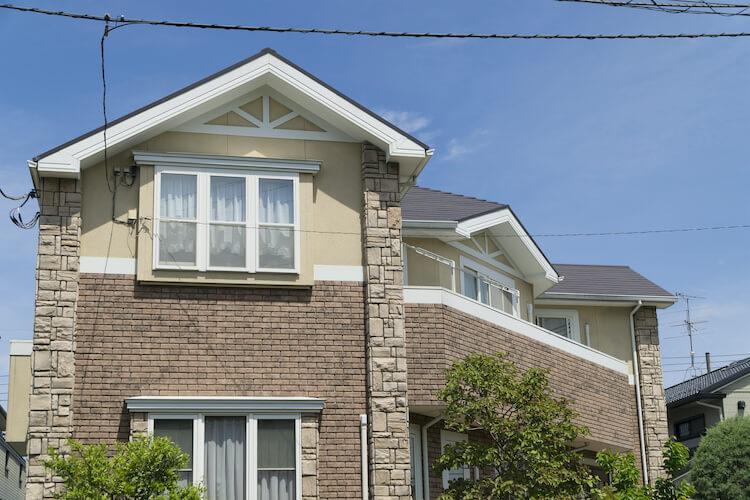 外壁の角にレンガ飾りをほどこした一軒家