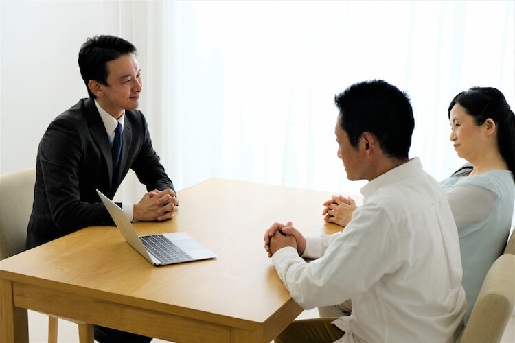 塗装業者の営業マンと話す夫婦