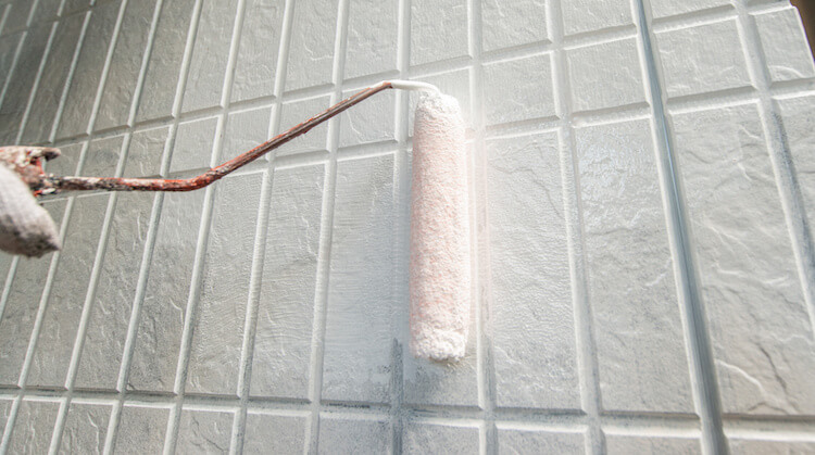 ローラーで外壁塗装するようす